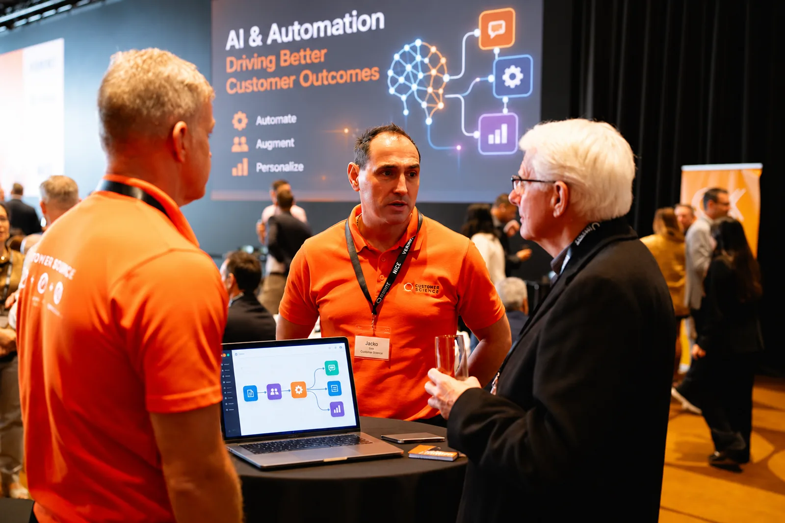 Customer Science team members talking with an attendee at the CX Showcase.