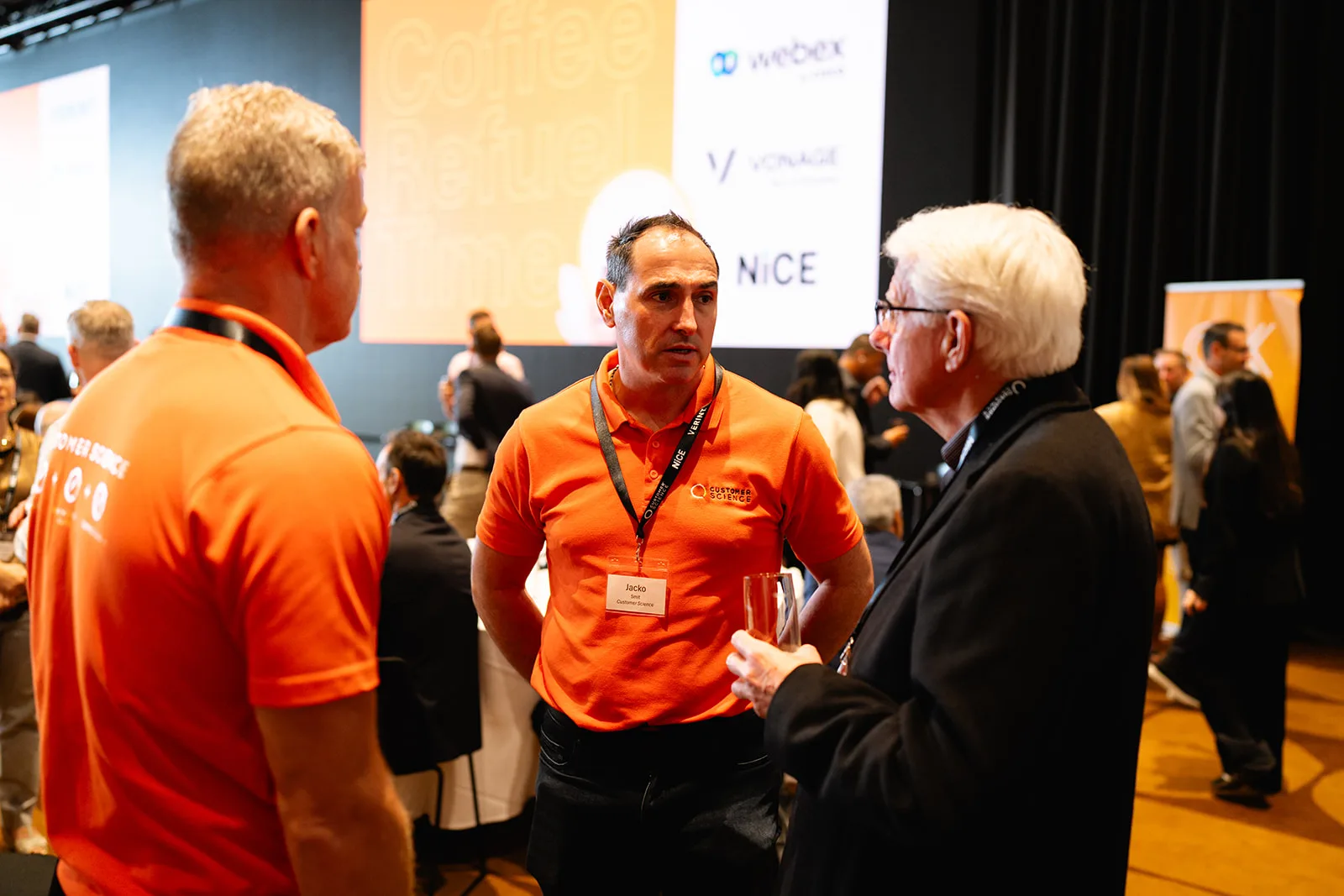 Customer Science team members talking with an attendee at the CX Showcase.