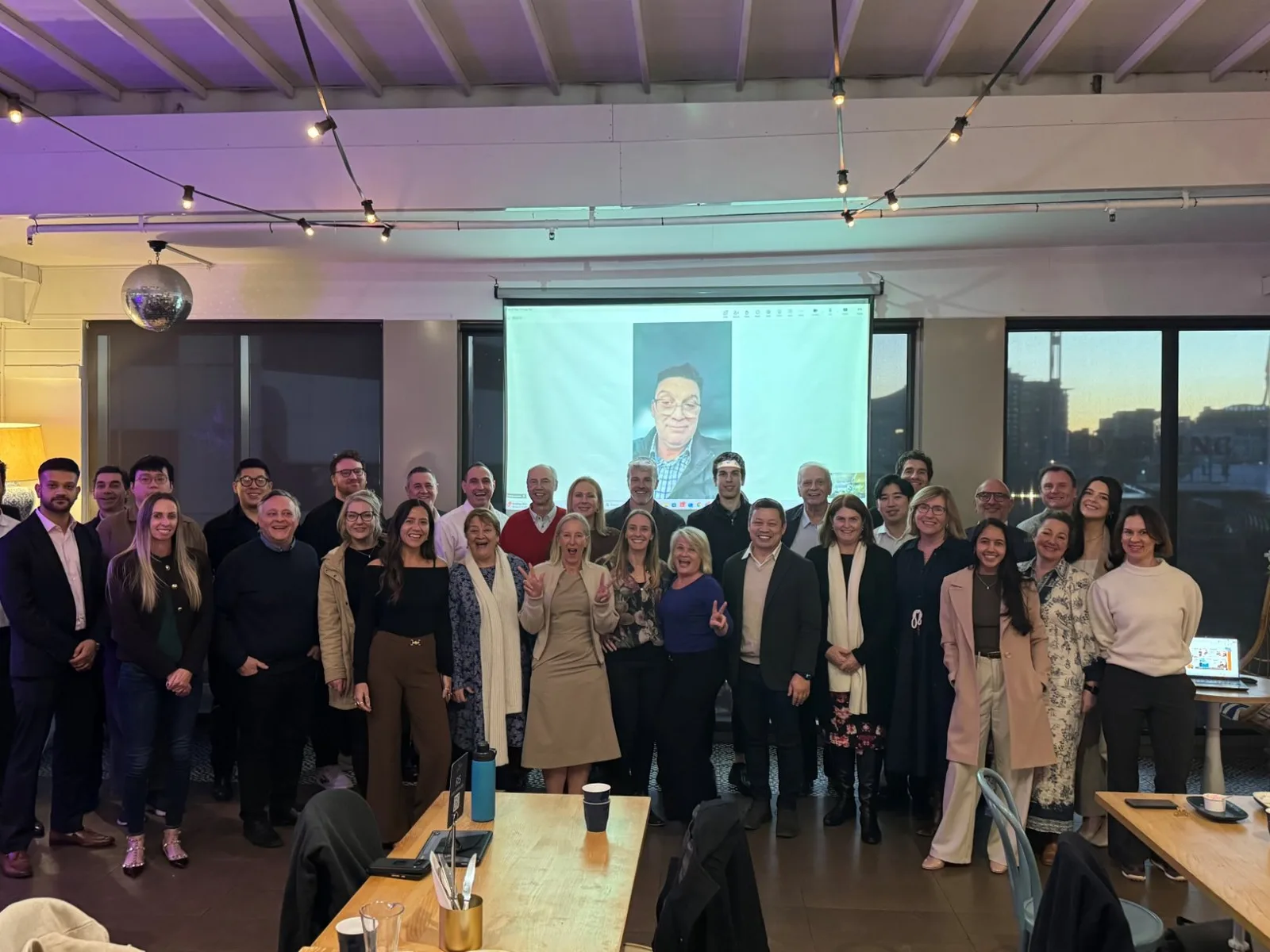 Customer Science colleagues gathered together at a team offsite, with a remote colleague joining on screen.